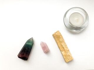 Palo santo incense stick for meditation, candle and rose quartz crystal on a white background,...