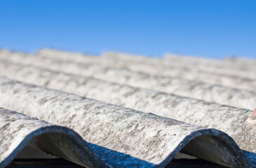 Old aged dangerous roof made of corrugated asbestos panels - one of the most dangerous materials in...