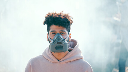 Portrait of Sad Young Man in Gas Mask Standing in Toxic Smoke. Activists worry about environmentalism. Saving the Planet.