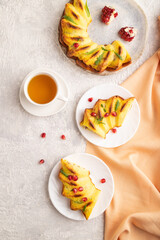 Cheesecake with cup of tea on gray concrete background and orange textile, top view, close up.