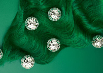 Unusual bright green natural hair colored with pigments. Beauty salon background for stories. .Small disco balls decoration like a Christmas tree