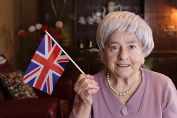 Patriotic senior woman waving the beautiful Great Britain national flag