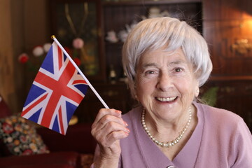 Patriotic senior woman waving the beautiful Great Britain national flag