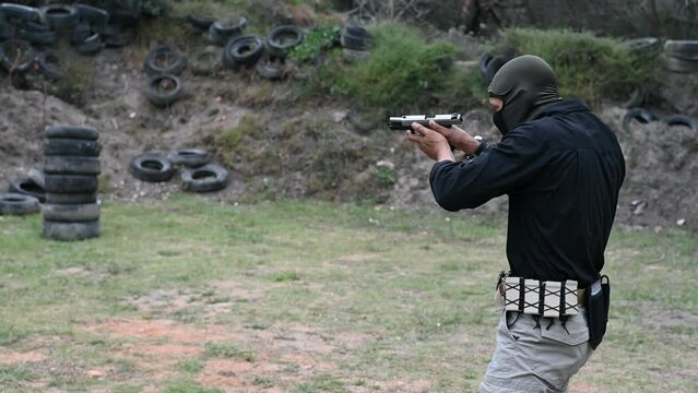 Close up shot of man firing handgun at outdoors range