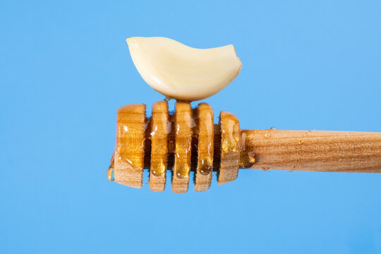 Fermented garlic honey close up on a blue background. Copy Space