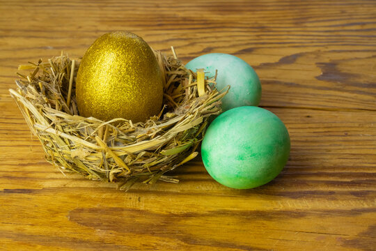 Image of a golden egg and colored eggs for Easter.