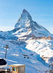 Picturesque alpine landscape with view of chairlift station of modern ski resort at foot of high...