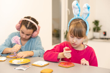 two little girls making gingerbread cookies at home.