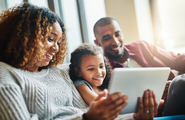 Raising a tech conscious little girl. Shot of an adorable little girl and her parents using a...