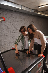 Vertical shot of two students playing air hockey at games room at the campus