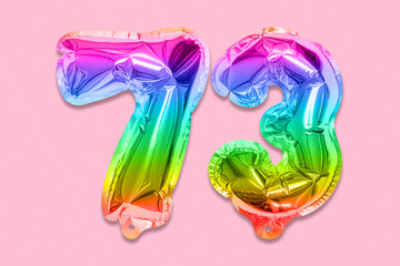 Rainbow foil balloon number, digit seventy three on a pink background. Birthday greeting card with inscription 73. Top view. Numerical digit. Celebration event, template.