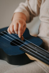 A child plays a small blue guitar
