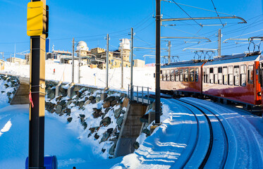 Red swiss train running through the snow