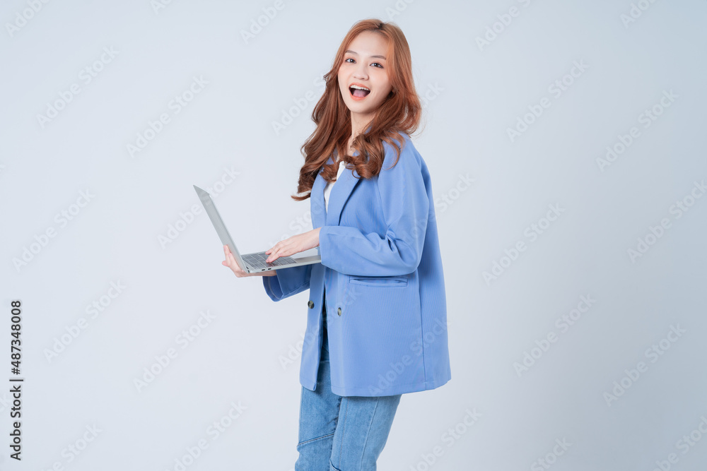 Wall mural young asian businesswoman using laptop on white background