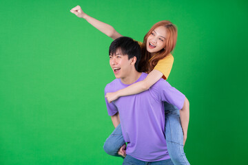 Young Asian couple posing on green background