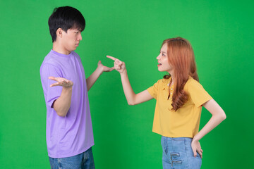 Young Asian couple posing on green background