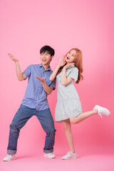 Young Asian couple posing on pink background