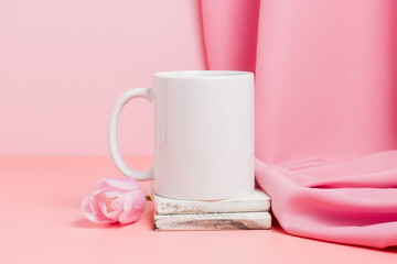 Mockup mug on wooden coaster with tulip and pink textile at the background. Mug for design and ad, spring concept