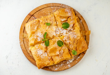bougatsa is a sweet pastry made from crispy filo dough with a custard filling. Top view.