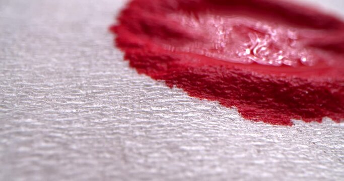 Red blood concept. Red blood drops onto a white cloth, blood is absorbed into a white paper napkin, macro shot.