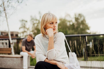 Mature couple in a bad mental condition after a quarrel outdoors. Adult couple man and woman trying...