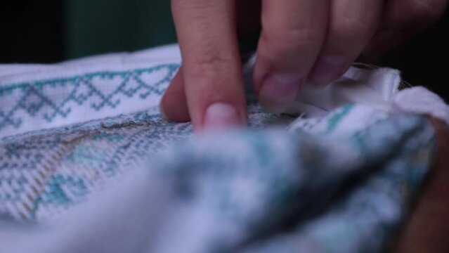Hands cut threads on hand embroidery. Ukrainian national vyshyvanka