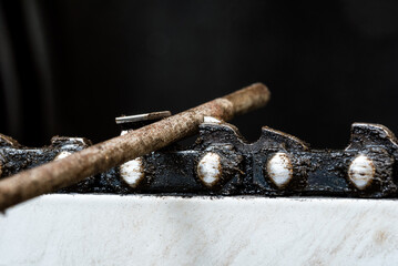Chainsaw chain sharpening with file. Closeup macro shot