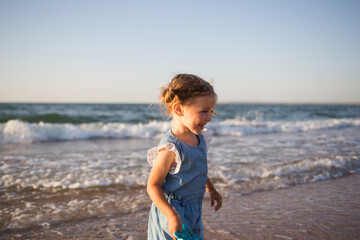happy small child runs along beach on sea. kids fun in summer.