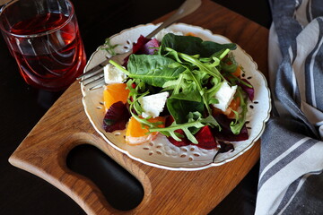 Salad with beetroot, arugula,feta cheese, orange, spinach on gray background top view. Healthy food. Spring salad