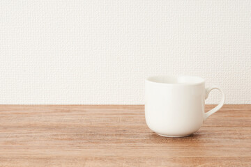 Fototapeta na wymiar コーヒーカップ　木目　白い壁
