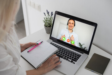 Caucasian female teacher using computer and laptop on video call with school children. Online...