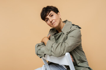 Mature european woman looking at camera while sitting on chair