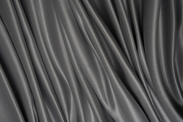 Beautiful elegant wavy grey satin silk luxury cloth fabric texture with monochrome background design. Wallpaper, banner