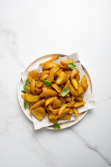 Golden roasted potatoes wedges on plate from above food