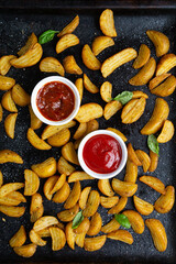 Roasted potatoes wedges on baking tray food overhead view and dips