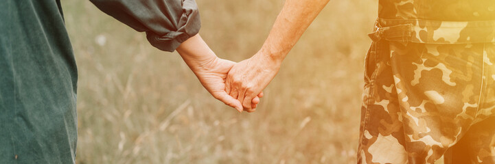 happy senior couple holding hands. hands of man and woman hold each other. romance and love and support in elderly family. husband and wife travel together in nature. countryside life. banner. flare