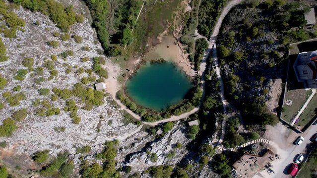 Top Down Descent Towards Vibrant Teal Blue Natural Oval Spring Valley Cetina River Croatia Drone 4k