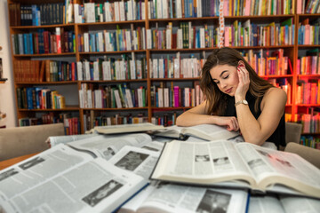 female student looking for book in university library