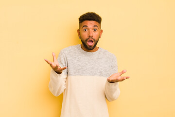 young afro man feeling extremely shocked and surprised, anxious and panicking, with a stressed and...