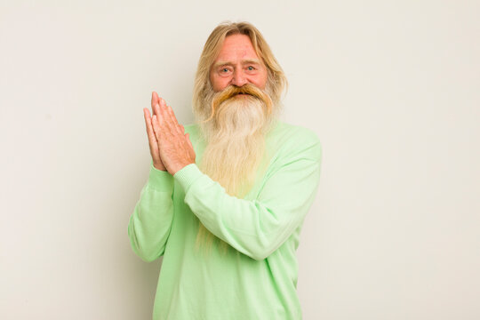 senior cool bearded man feeling happy and successful, smiling and clapping hands, saying congratulations with an applause