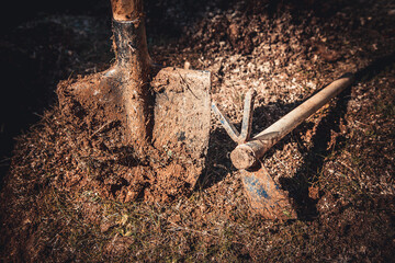 Used gardening shovel and hoe with soil on it, vintage colors background photo. Gardening, spring,...
