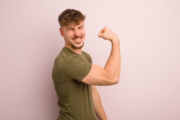 young cool man feeling happy, satisfied and powerful, flexing fit and muscular biceps, looking strong after the gym - Powered by Adobe