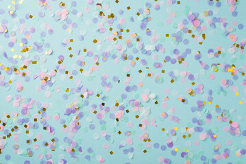 Top view photo of easter decorations gold pink and violet confetti on isolated pastel blue background