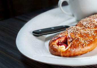 Sweet bread stuffed with strawberry jam and cheese, with sesame seeds, traditional Mexican bread from Oaxaca, over a white christmas plate.