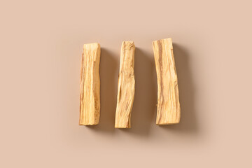 Palo Santo three stick on beige background. Minimal style. Ritual cleansing, meditation, spiritual practice. View from above.