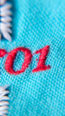 Número 01 bordado con hilo rojo en tejido de algodón azul