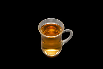 A turkish glass of tea on black background.