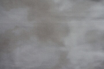 Swatch of viscose and polyester fabric with tie dye pattern in shades of gray