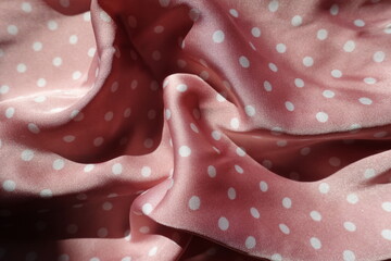 Draped satin fabric with pink and white polka dot pattern