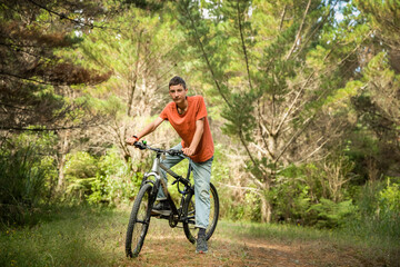 Fototapeta na wymiar happy teen boy riding a bike on natural background, forest or park. healthy lifestyle, family day out. High quality photo
